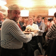 Torupillihelide ja aplausi saatel toodi saali pearoog – soolakoorikus küpsetatud kohakala. Pildil vasakult Imre Kivi, esiplaanil Tauno Laasik, eemalt kiikab Ants Uustalu, keskel Heli Hahndorf, tema selja taga Kalle Talvi ja kõrval Siim Rätsep, kelle tagant vaatab Tiiu Koppel.