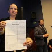 Kristi Ugam näitas Siim Paistile (tagaplaanil) tühja allkirjalehte tekstiga, millele kaheksa aastat tagasi allkirju koguti.