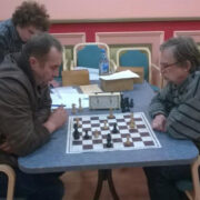 Paremal turniiri võitja Andres Ihermann, vasakul teise koha saanud Aiver Kark ja poisid, kes huviga mängu käiku jälgivad.