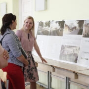 Hoolekogu liige Liis Soonik (seljaga), lapsevanem Margit Pruul ja koolijuht Margit Kagadze tutvumas uue koolihoone ümber planeeritava roheala kavandiga.