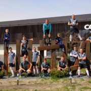 Jalgpalliklubi liikmed Hiiumaa maamärgi juures, mille püstitas klubi üks toetajaid, kohalik tarbijate ühistu. Paremal FC Hiiumaa treener Mario Degtjov, esireas paremalt neljas klubi tegevjuht Georg Linkov, vasakult esimene Kristi Linkov.