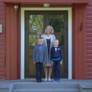 Esimese klassi õpetaja Siiri Pielberg ja tema kaks õpilast värskelt värvitud koolimaja ees.