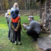 Muuseumi teadur Kauri Kiivramees ja lapsed Mihkli talumuuseumis.